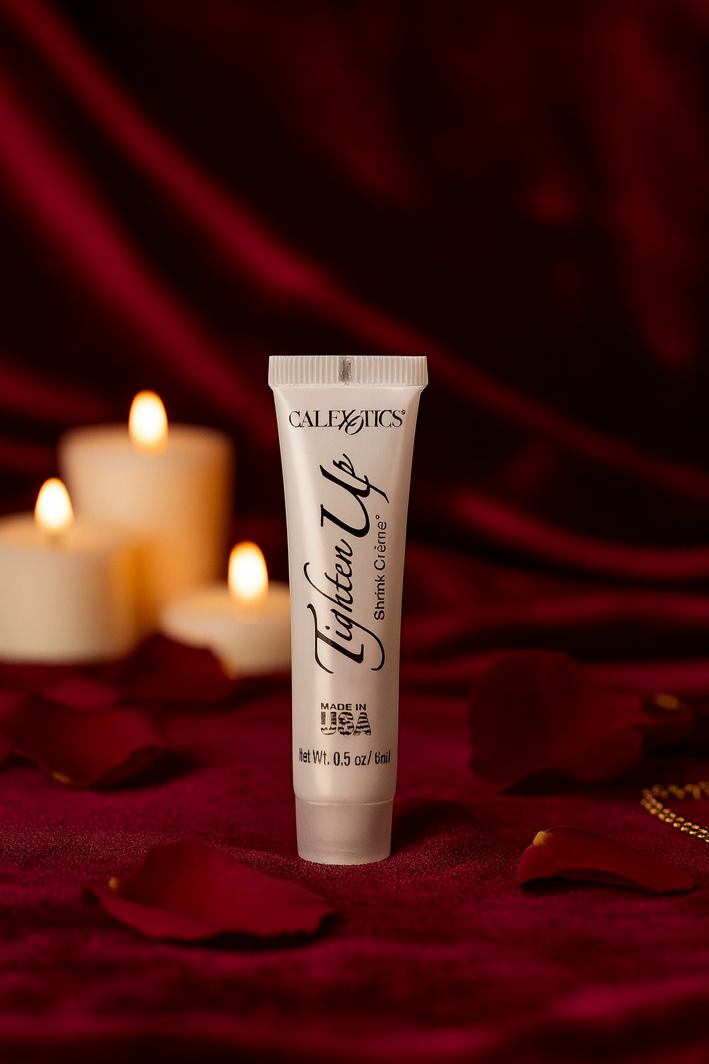 CalExotics Tighter Up vaginal tightening cream tube on red fabric with candles and rose petals