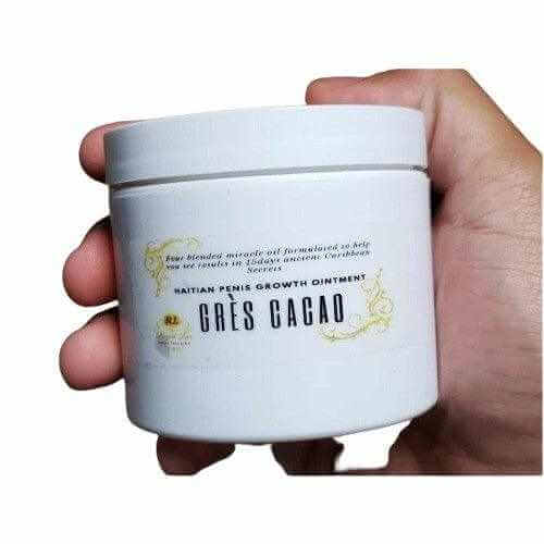 Hand holding a jar of Haitian Gres Cacao men’s wellness blend male enhancement ointment